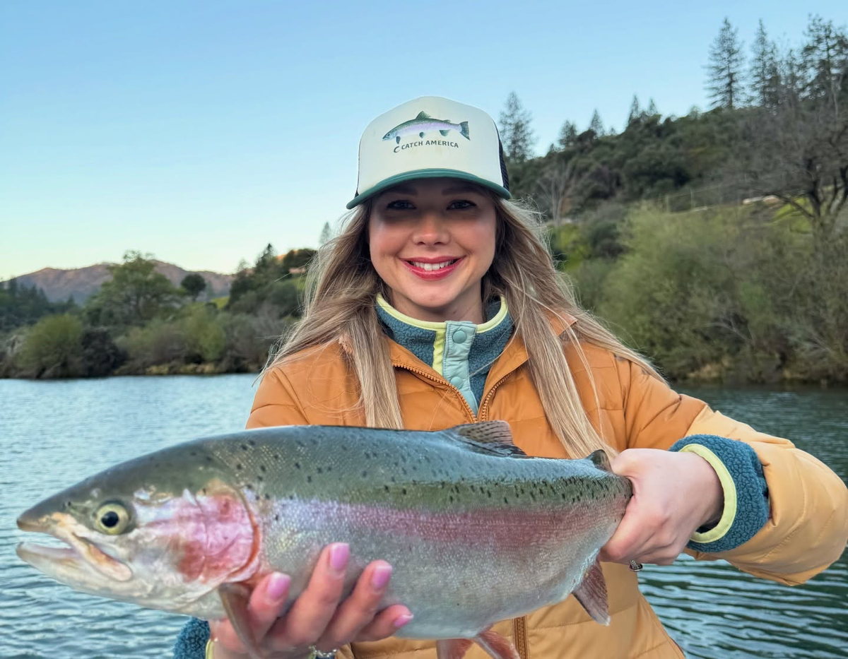 Angler holding a rainbow trout on the water; fishing photo, not a picture of bundle contents