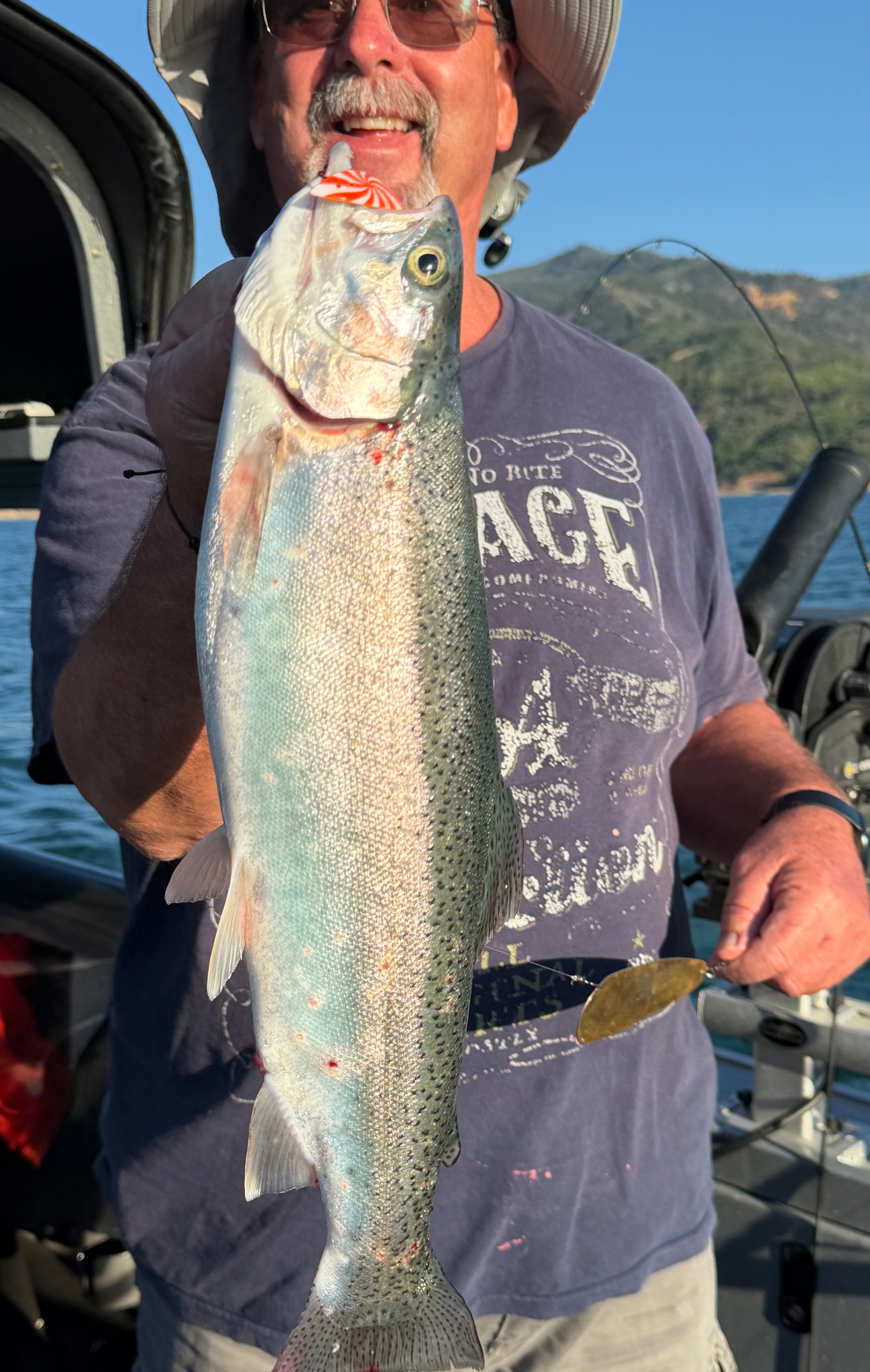 Angler holding a big trout caught on X-Pex with a gold dodger
